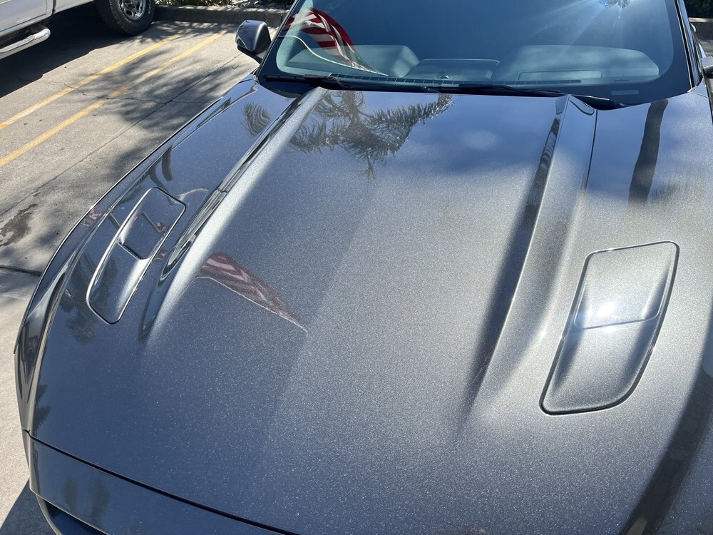 Corrected grey Mustang hood reflecting the afternoon sky