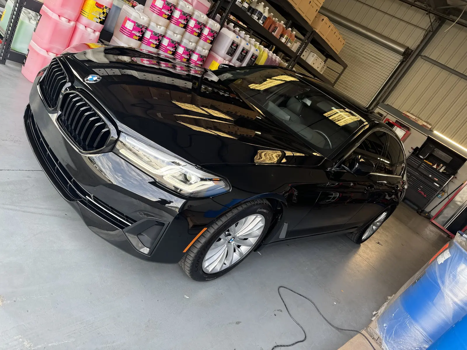 Black BMW being detailed in the shop bay